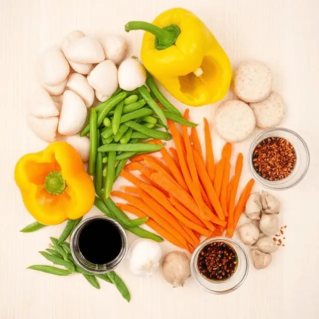 Fresh ingredients for making fishcakes and scallops stir fry, including vegetables and sauces.